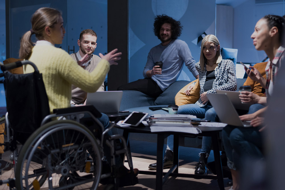 Woman in wheelchair talking to colleagues